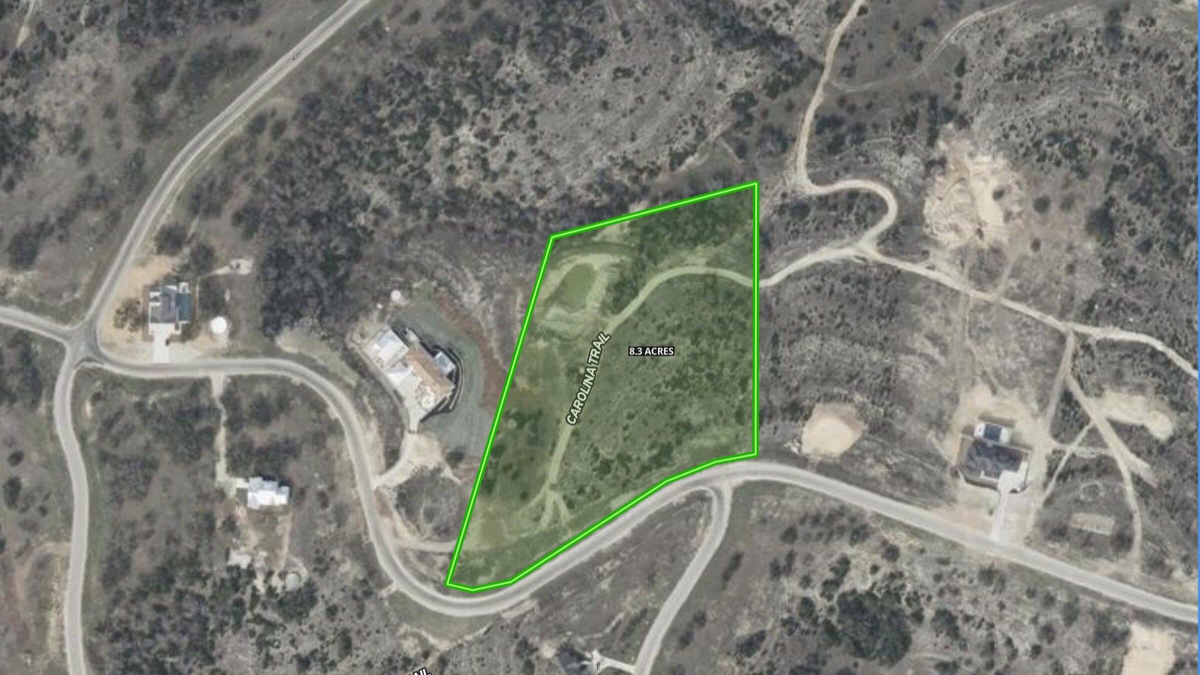 Aerial view of the 8.3-acre hillside tract with the surveyed parcel boundary outlined; Falling Oak Drive runs along the lower edge of the lot.